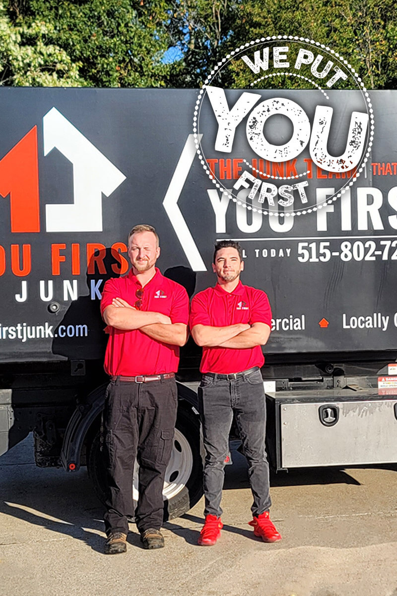 two you first moving's movers are standing in front of the moving truck wearing red branded shirts